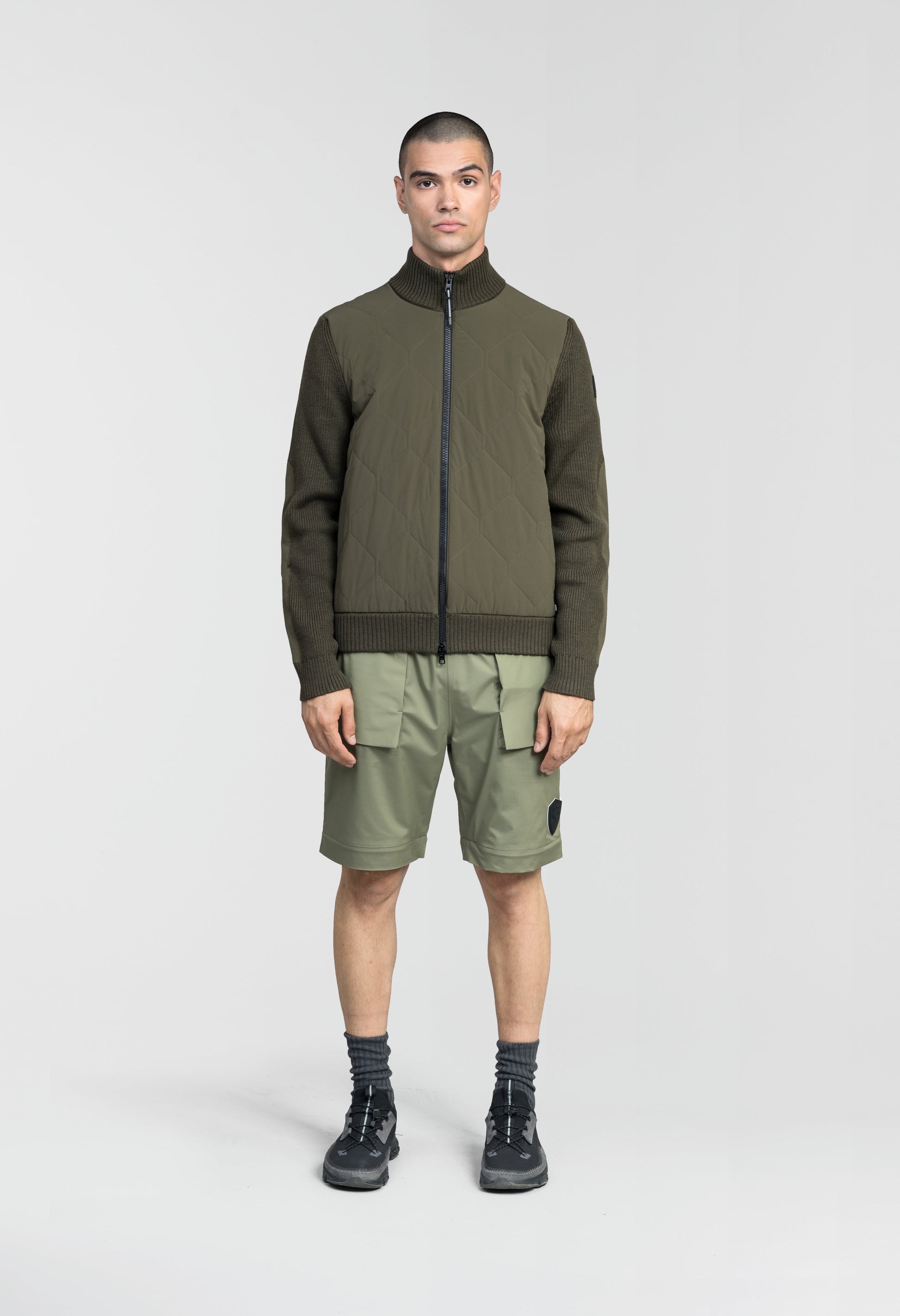 Ero Men's Tailored Hybrid Sweater in hip length, PrimaLoft Gold Insulation Active+, Durable 4-Way Stretch Weave quilted torso, Merino wool knit collar, sleeves, back, and cuffs, two-way front zipper, and hidden waist pockets, in Fatigue