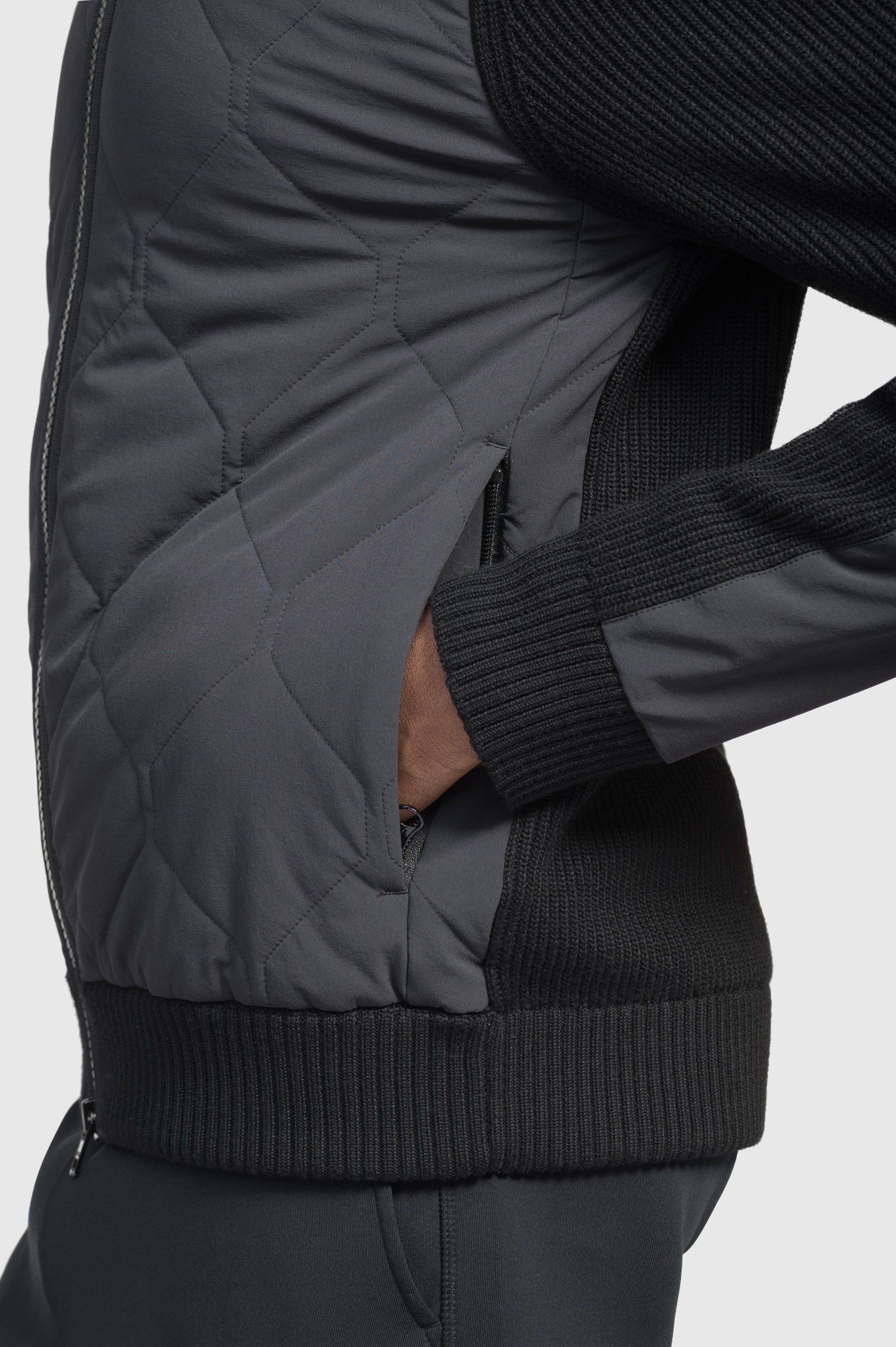 Ero Men's Tailored Hybrid Sweater in hip length, PrimaLoft Gold Insulation Active+, Durable 4-Way Stretch Weave quilted torso, Merino wool knit collar, sleeves, back, and cuffs, two-way front zipper, and hidden waist pockets, in Black