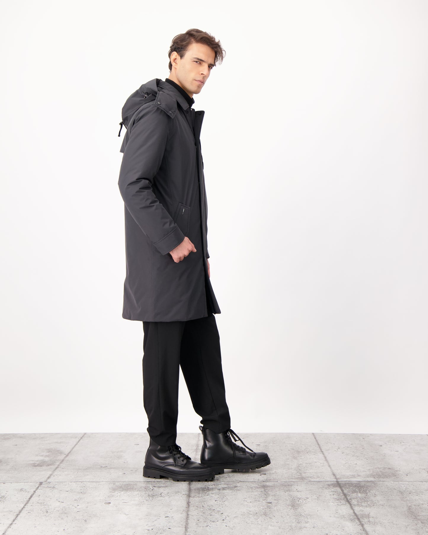 Nord Men's Tailored Trench Coat in knee length, 3-Ply Micro Denier and 4-Way Durable Stretch Weave fabrication, Premium Canadian White Duck Down insulation, removable down-filled hood, exterior zipper pocket at left chest, and adjustable snap button cuffs, in Black