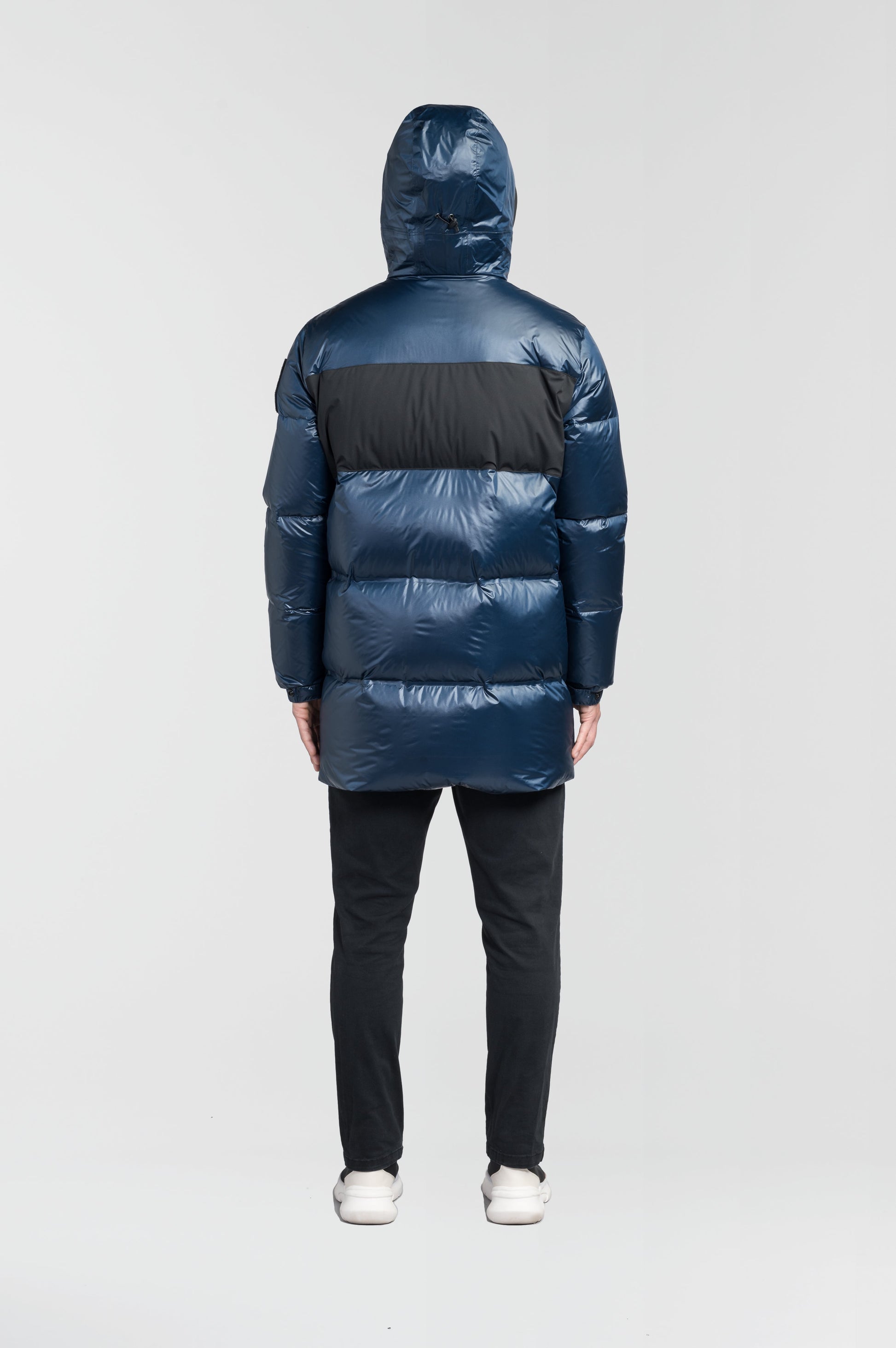 Neelix Men's Long Puffer Jacket in thigh length, premium cire technical nylon taffeta and stretch ripstop fabrication, Premium Canadian origin White Duck Down insulation, non-removable down-filled hood, two-way centre-front zipper, pit zipper vents, hidden chest zipper pockets, fleece-lined magnetic closure waist pockets, in Marine