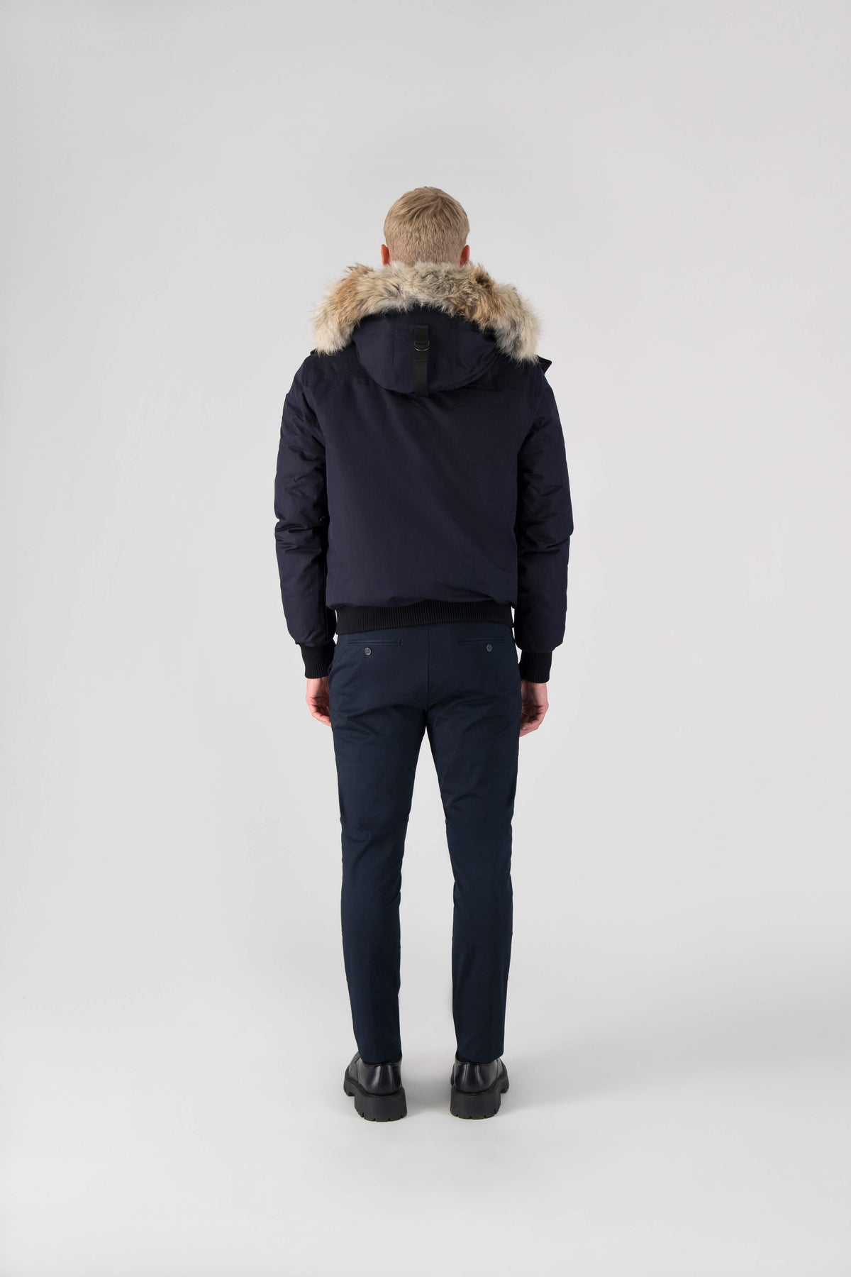Men's down filled bomber that sits just above the hips with a completely removable hood that's windproof, waterproof, and breathable in Navy