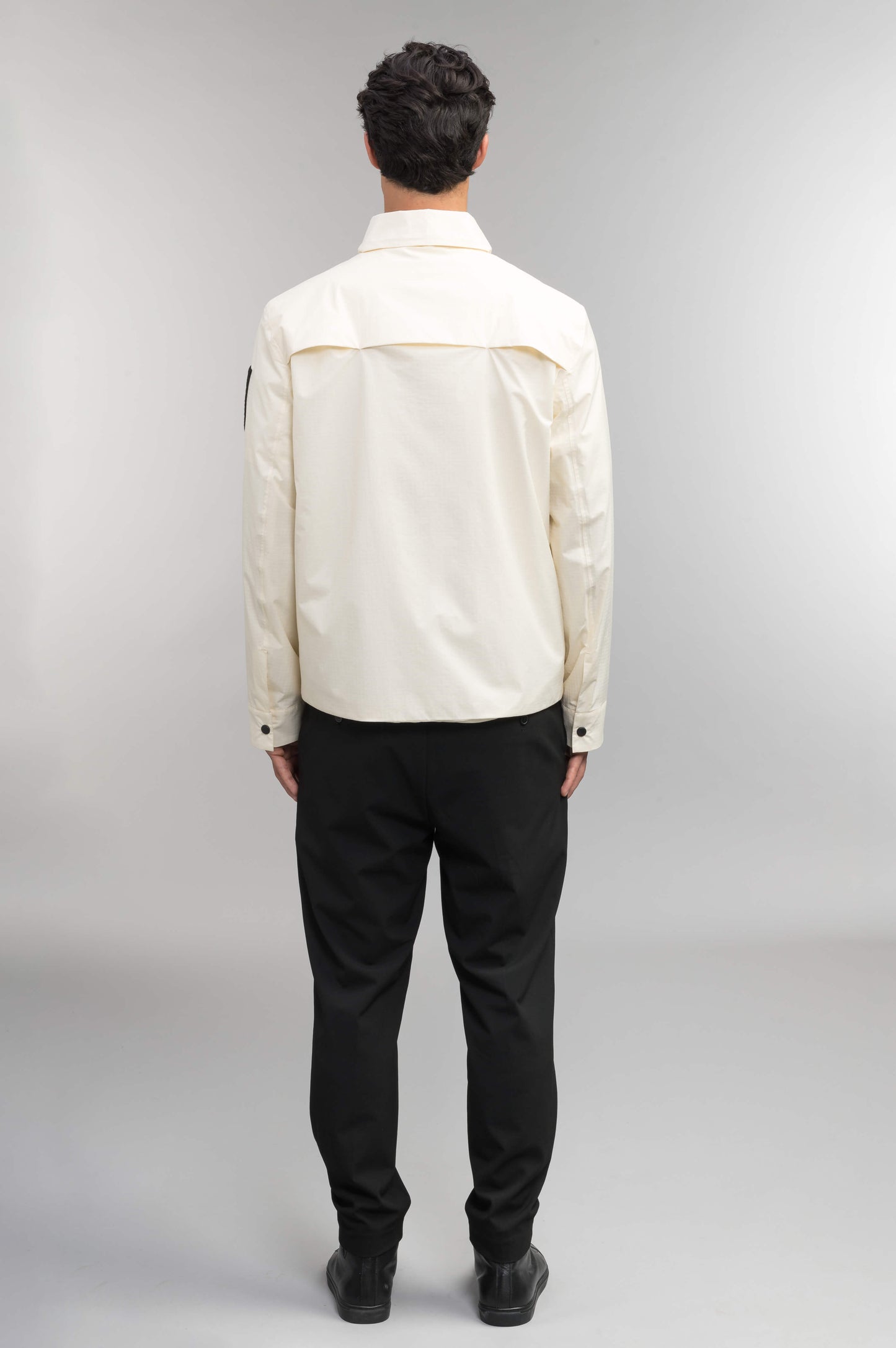 Farson Men's Waterproof Overshirt in Wheat made from premium recycled polyester ripstop with a DWR coating. Features a concealed snap-button front placket, adjustable snap cuffs, invisible chest zip pocket, dual zippered waist pockets, pit zip ventilation, and seam-sealed construction for enhanced weather protection. Designed in Canada.