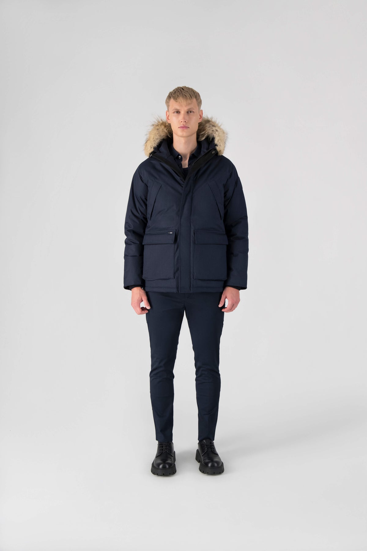 Men's waist length down filled jacket with two front pockets with magnetic closure and a removable fur trim on the hood in Navy