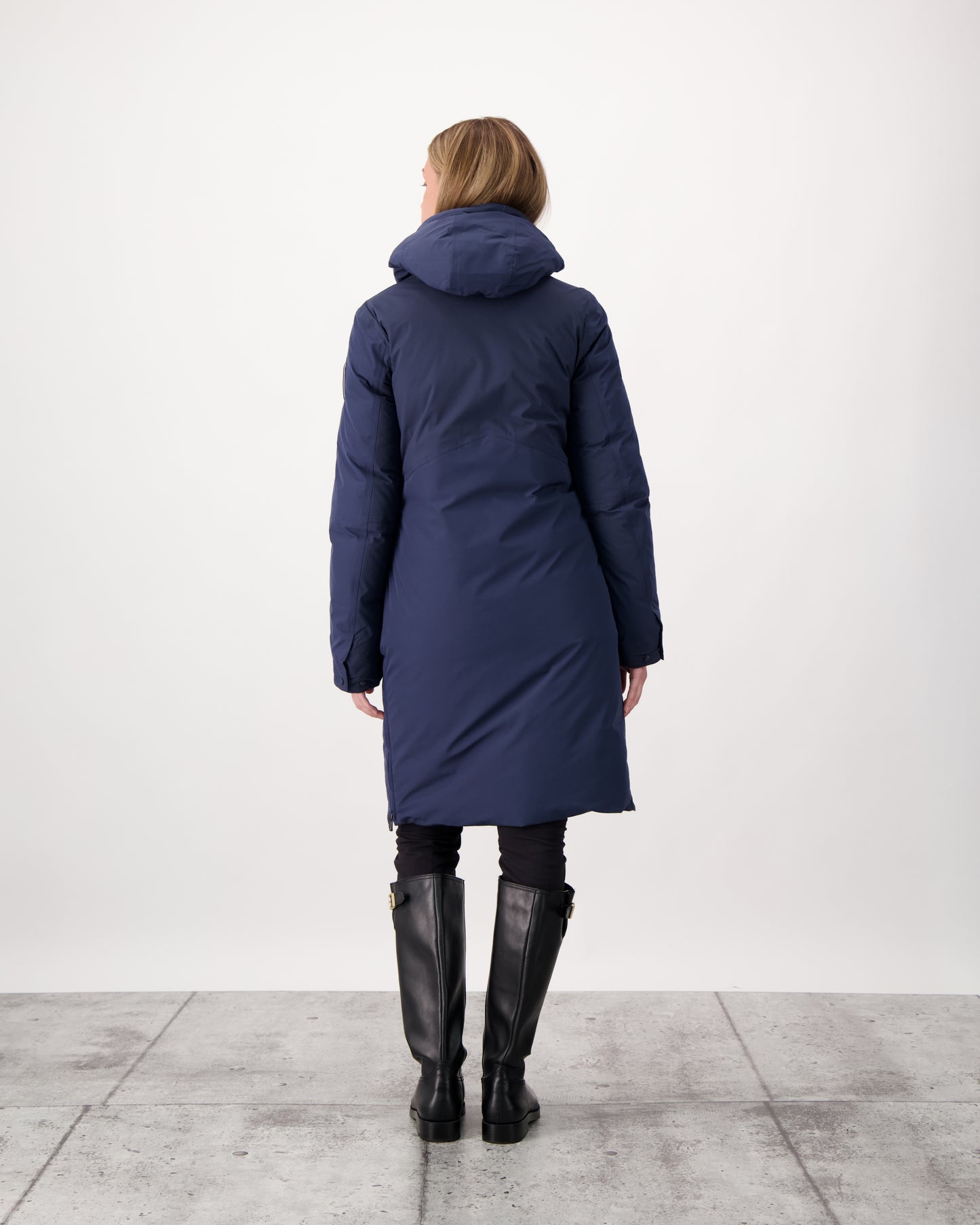 Inara Women's Performance Parka in knee length, premium 3-ply micro denier and stretch ripstop fabrication with DWR coating, Premium Canadian White Duck Down insulation, non-removable down-filled hood, centre front two-way zipper, large vertical zipper pockets along waist, zipper vents along bottom side hem, in Marine