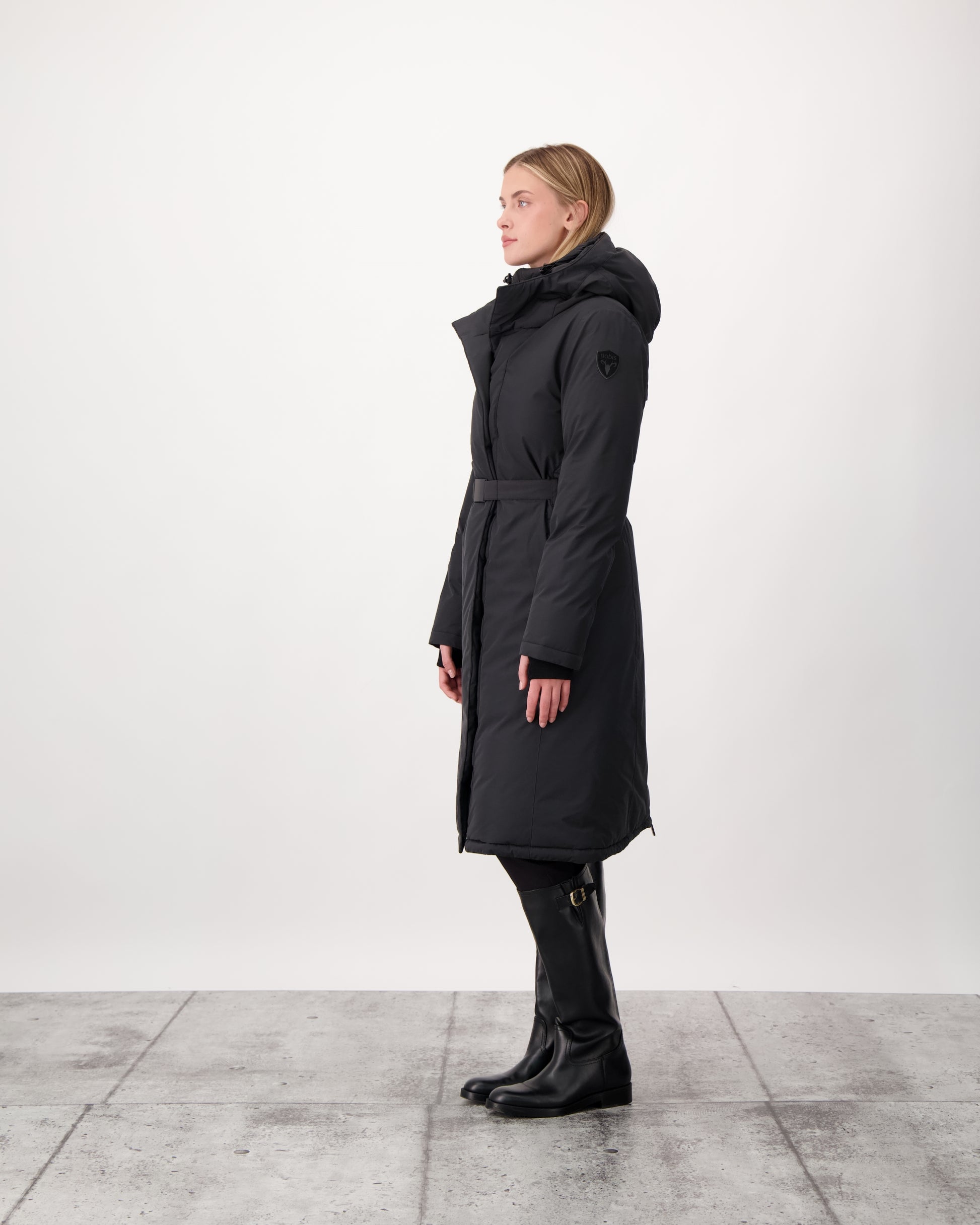 Long calf length hooded women's winter parka with an inner hip length closure, exterior hem length zipper and magnetic placket in Black
