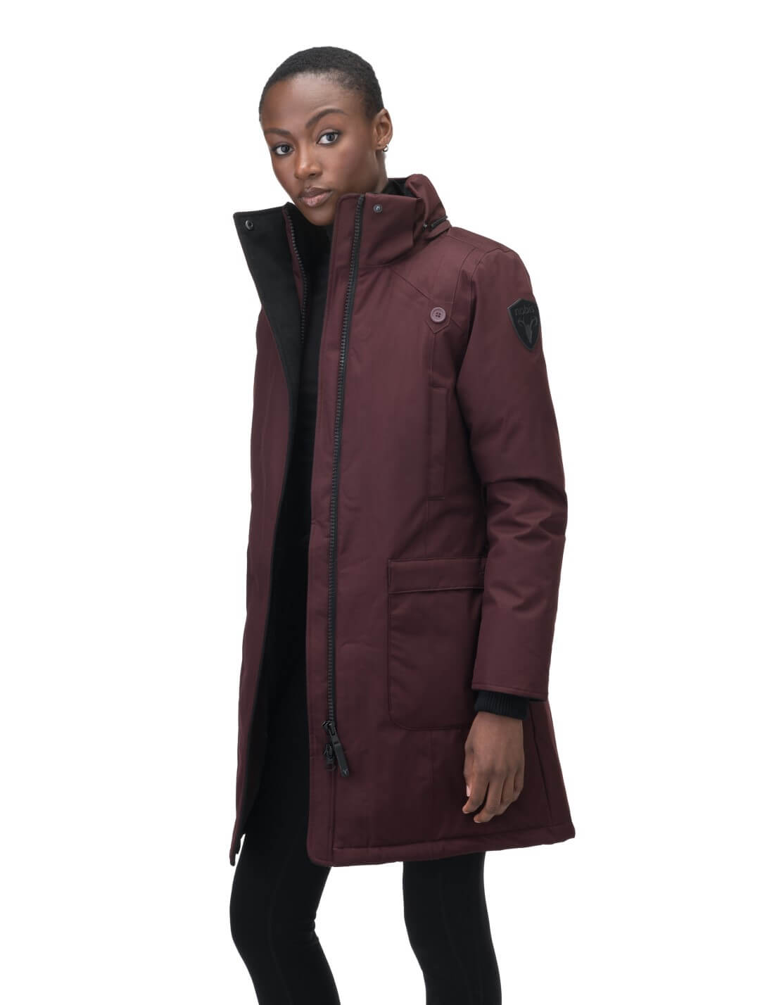 Merideth Furless Ladies Parka in thigh length, Canadian white duck down insulation, removable down-filled hood, centre-front two-way zipper with magnetic wind flap closure, four exterior pockets, and elastic ribbed cuffs, in Merlot