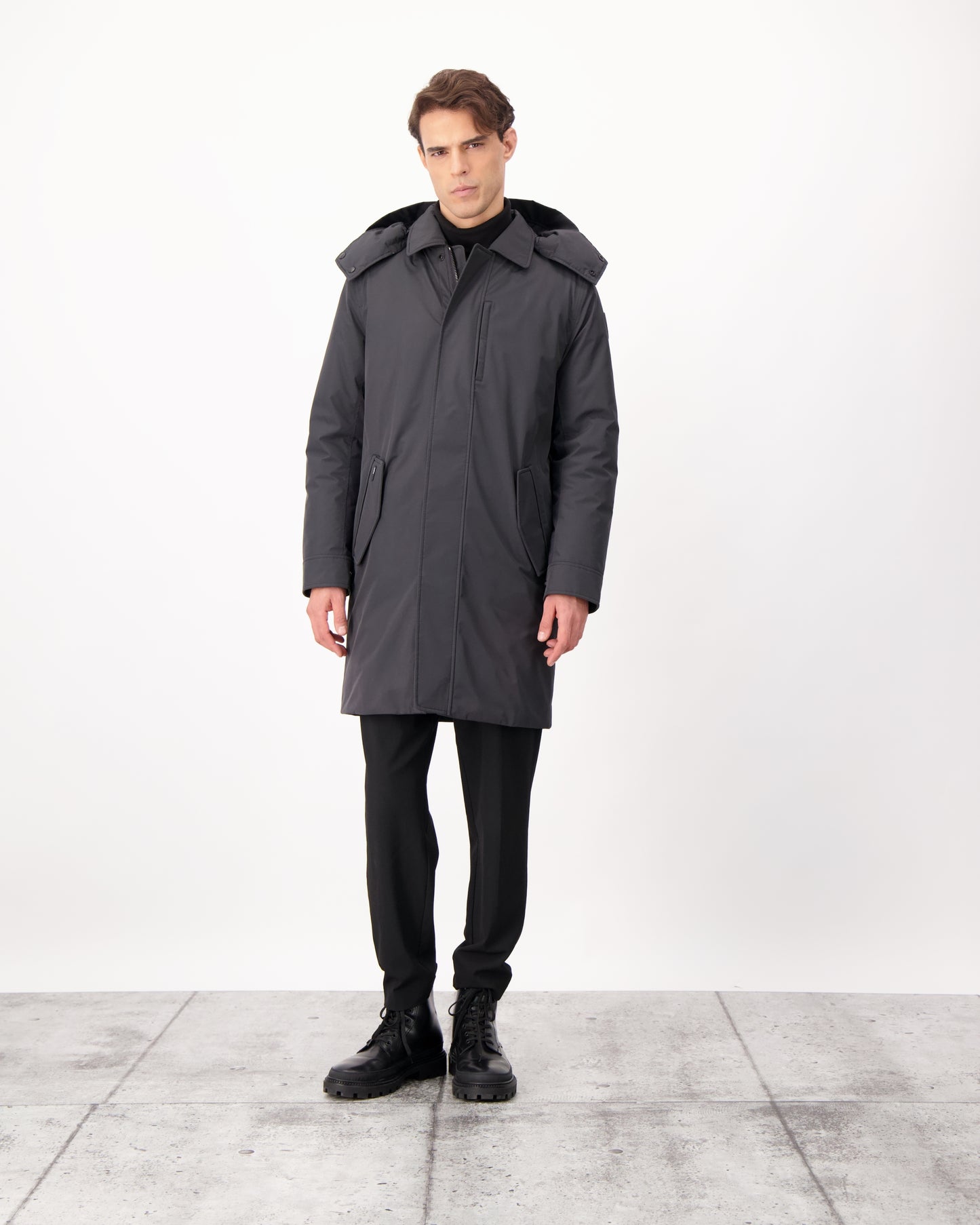 Nord Men's Tailored Trench Coat in knee length, 3-Ply Micro Denier and 4-Way Durable Stretch Weave fabrication, Premium Canadian White Duck Down insulation, removable down-filled hood, exterior zipper pocket at left chest, and adjustable snap button cuffs, in Black