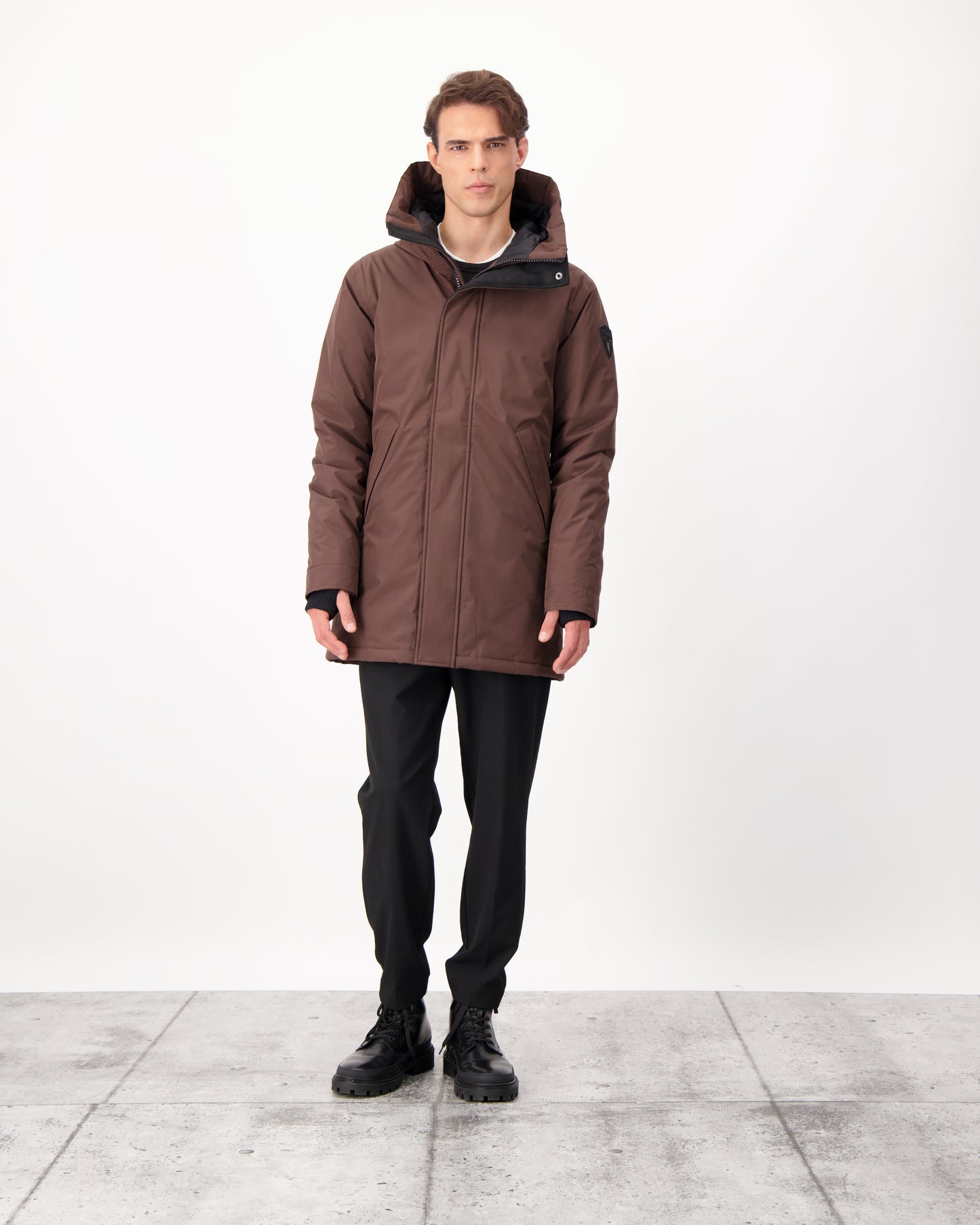 Pierre Men's Jacket in thigh length, Canadian white duck down insulation, non-removable down-filled hood, angled waist pockets, centre-front zipper with wind flap, and elastic ribbed cuffs, in 3L Coffee Bean