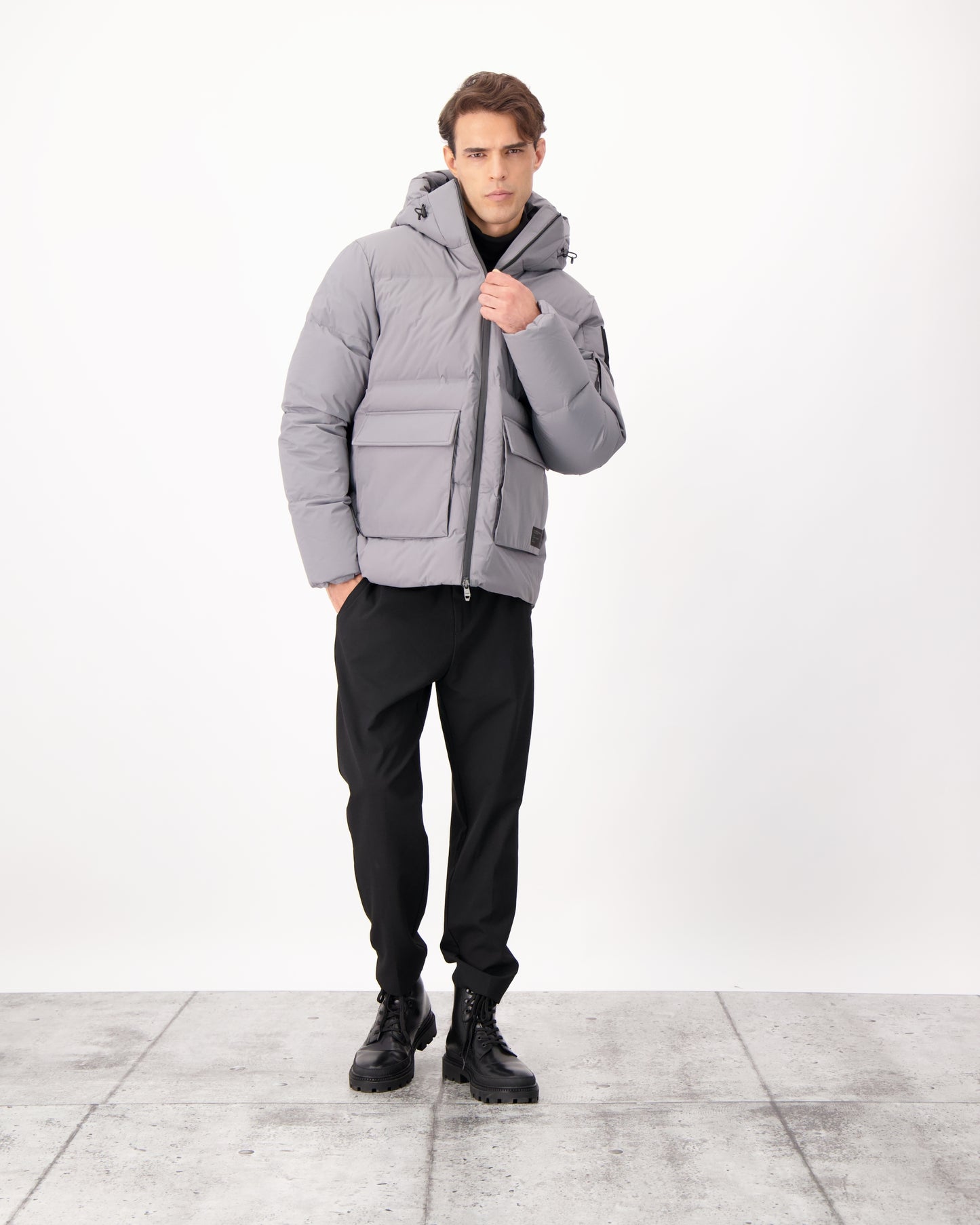 Supra Men's Performance Puffer in hip length, Technical Taffeta and 3-Ply Micro Denier fabrication, Premium Canadian White Duck Down insulation, non-removable down filled hood, centre front two-way zipper, flap pockets at waist, and zipper pocket at left bicep, in Concrete