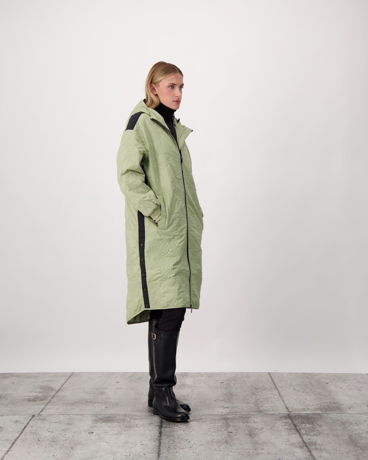 Surrey Women's Performance Quilted Long Mid Layer Jacket in knee length, Primaloft Gold Insulation Active+, non-removable hood, single welt magnetic closure pockets, ribbed cuffs, two-way centre front zipper, grosgrain ribbon detail and shoulders and side seam, and snap closure side seam vents, in Tea