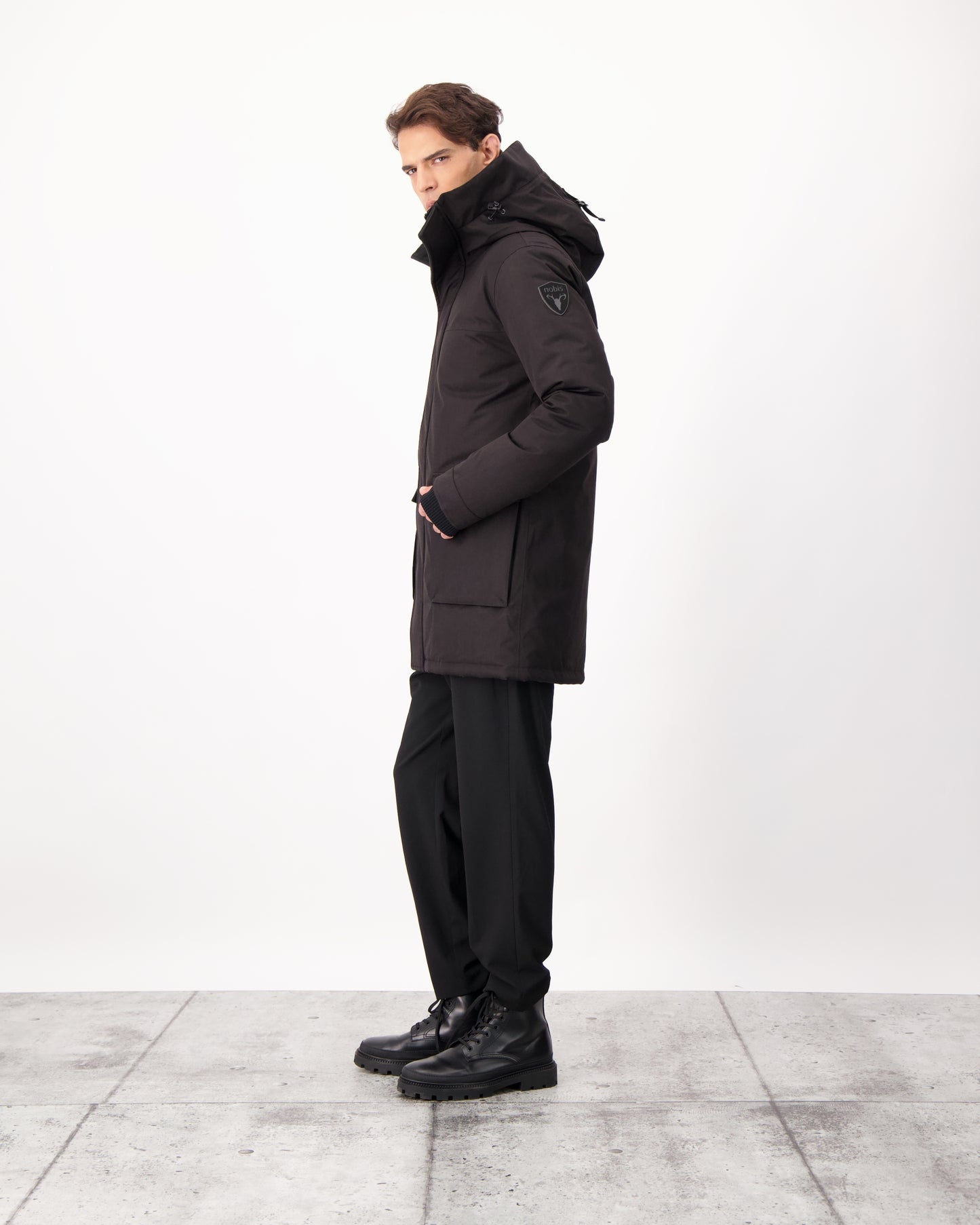 Yves Furless Men's Parka in thigh length, Canadian white duck down insulation, non-removable down-filled hood, flap pockets at waist, centre-front two-way zipper with magnetic wind flap, and elastic ribbed cuffs, in CH Black