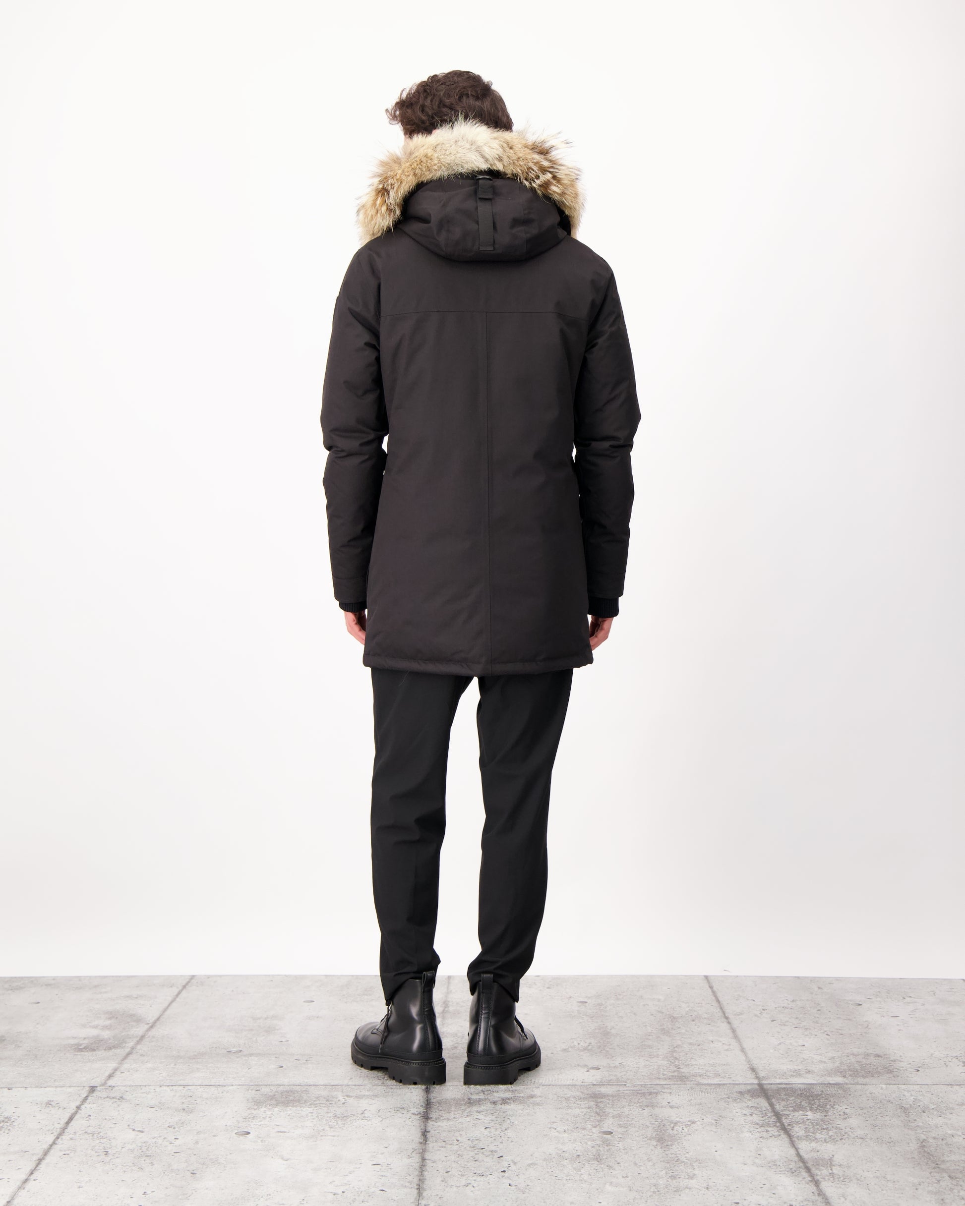 Men's slim fitting waist length parka with removable fur trim on the hood and two waist patch pockets in CH Black