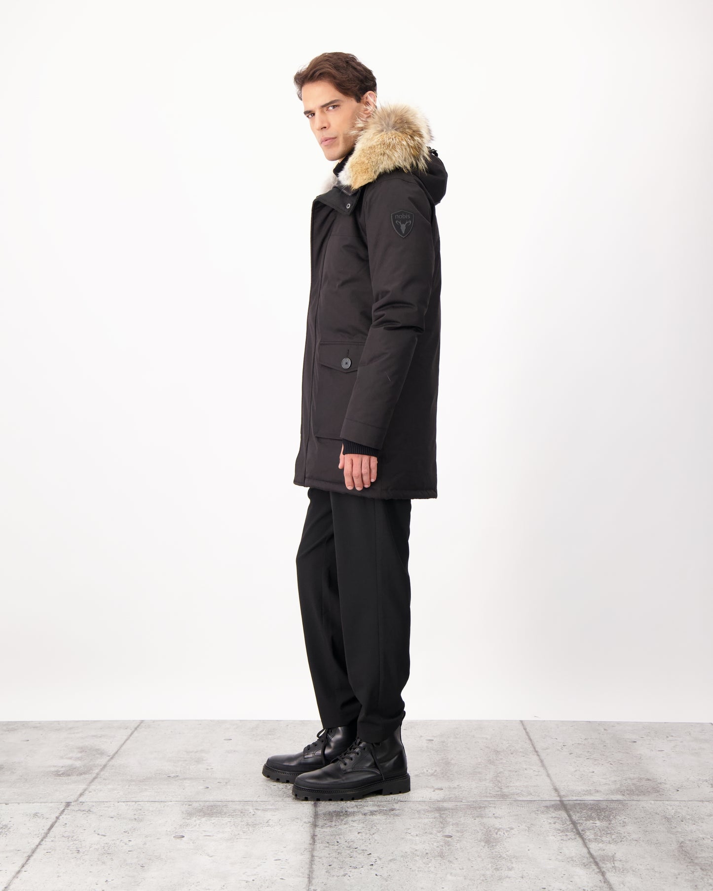 Men's slim fitting waist length parka with removable fur trim on the hood and two waist patch pockets in CH Black