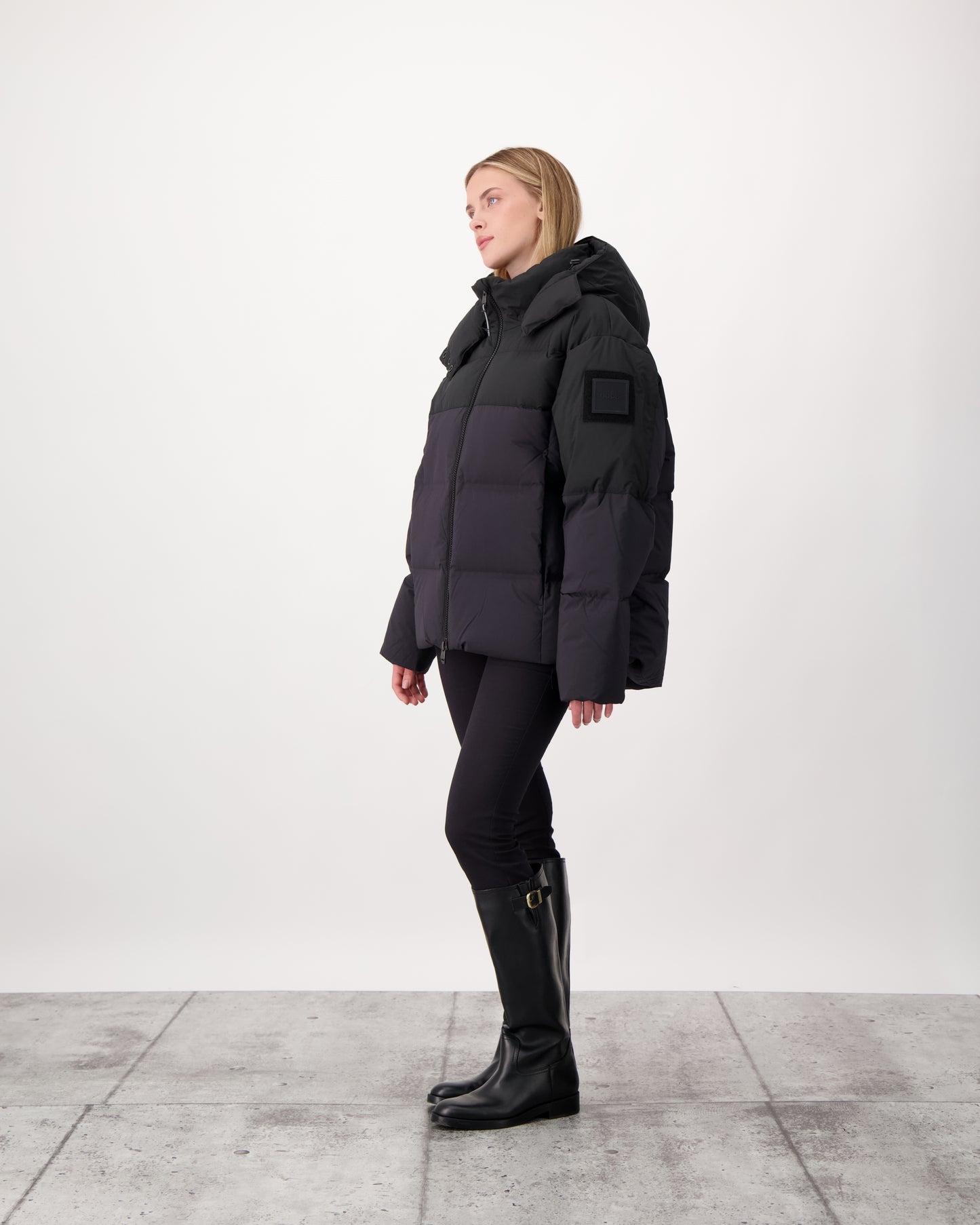 Una Ladies Performance Puffer in hip length, Technical Taffeta and Durable Stretch Ripstop fabrication, Premium Canadian White Duck Down insulation, removable down filled hood, centre front two-way zipper, and side-entry pockets at waist, in Black