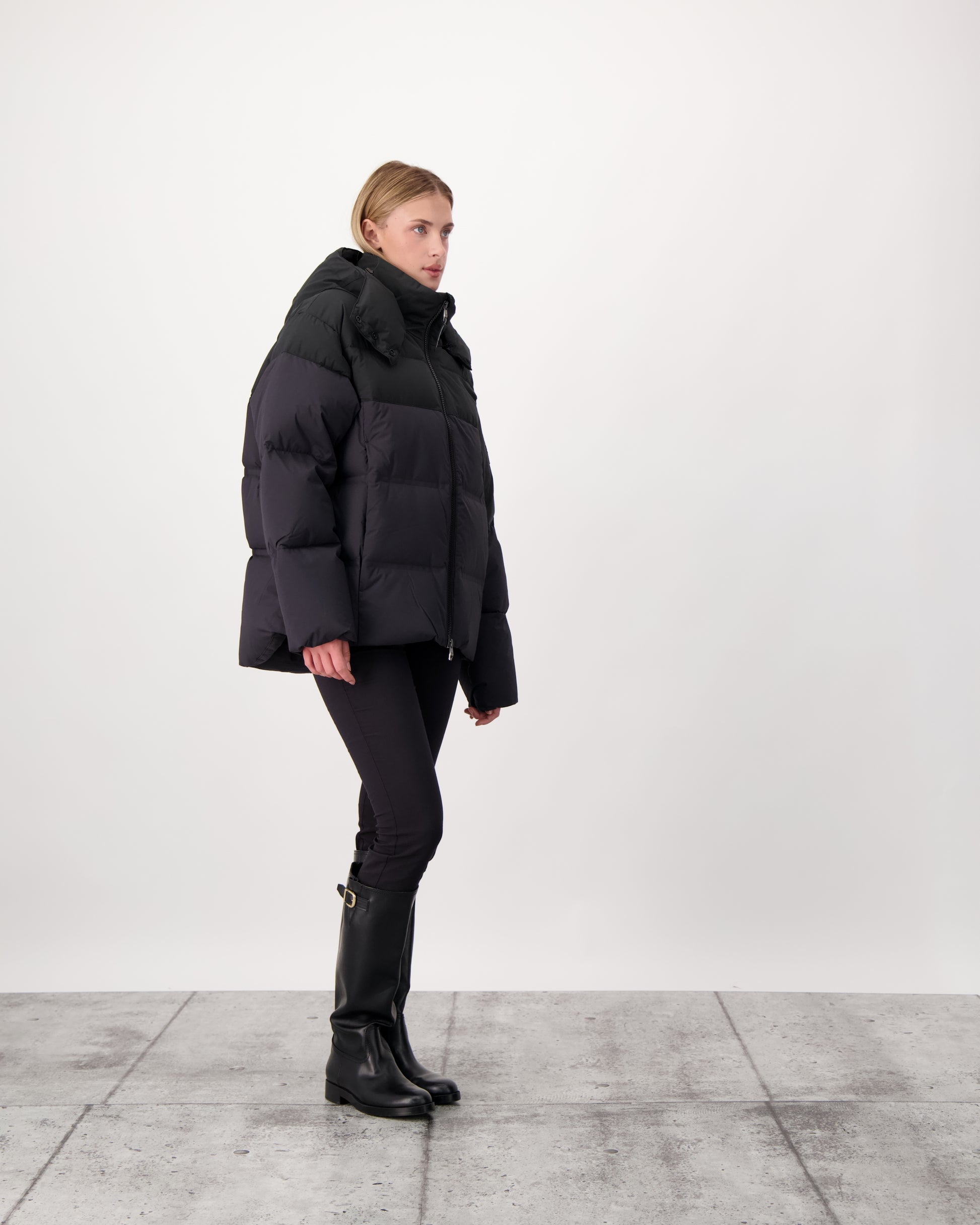 Una Ladies Performance Puffer in hip length, Technical Taffeta and Durable Stretch Ripstop fabrication, Premium Canadian White Duck Down insulation, removable down filled hood, centre front two-way zipper, and side-entry pockets at waist, in Black