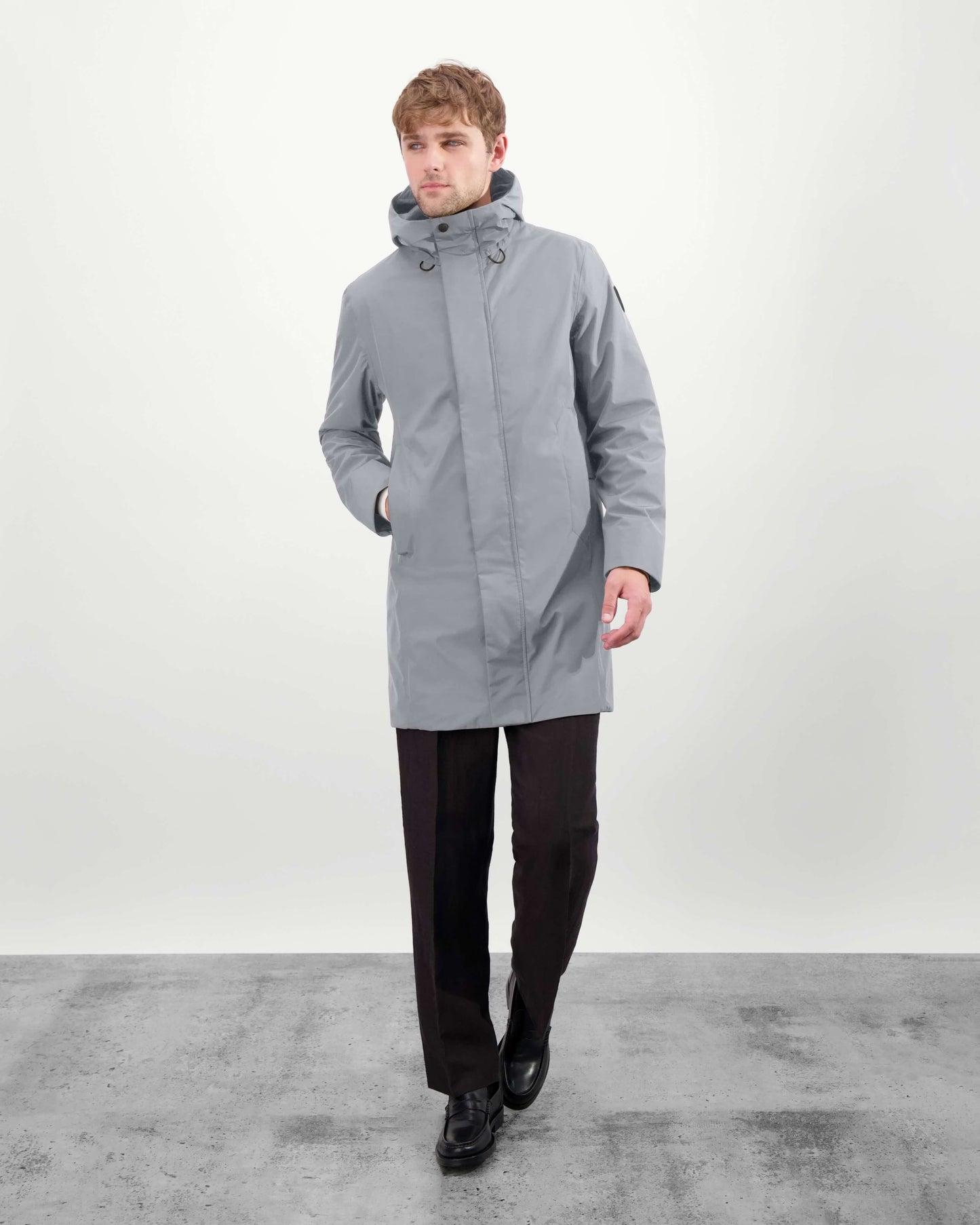 Upton long jacket in Concrete in 3-ply Micro Denier fabric with DWR coating, featuring a two-way zipper with magnetic closure, hidden mesh ventilation, and underarm vents. Designed for weather protection and tailored comfort.