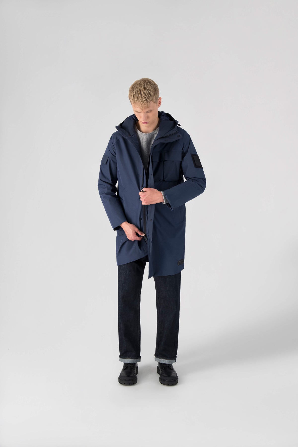 Wylder Men's Performance Rain Jacket in knee length, premium 3-ply Micro Denier and stretch ripstop fabrication, non-removable hood with reflective piping and adjustable draw cord, split utility chest pocket with magnetic flap closure, single welt pockets with magnetic closure at waist, back yoke with mesh ventilation, snap button wind flap, two-way branded zipper at centre front, telescopic sleeves with elasticized cuffs, interior draw cord at waist, in Marine