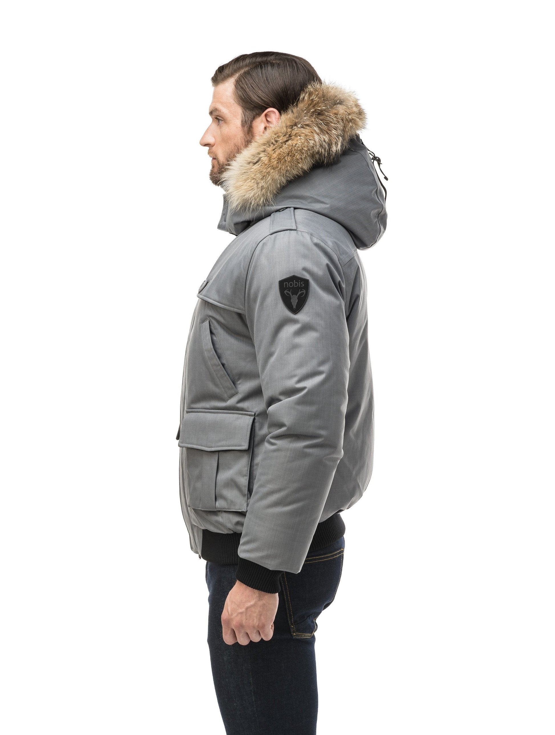 Men's down filled bomber that sits just above the hips with a completely removable hood that's windproof, waterproof, and breathable in CH Concrete