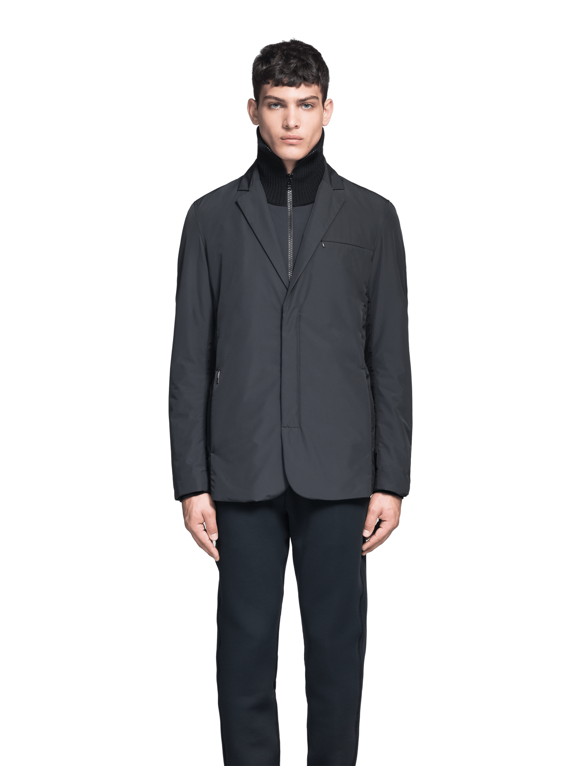 Cody Men's Tailored Travel Blazer in 3-ply micro denier and stretch nylon fabrication with DWR coating, Primaloft Gold Insulation Active+, hidden two-way zipper at centre front with snap closure placket, three invisible exterior zipper pockets, double back pleats, and hidden snap placket at cuffs, in Black