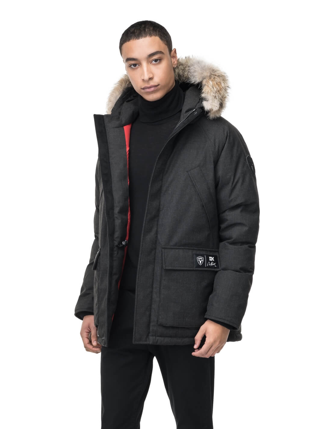 Duncan Keith Heritage Men's Parka in hip length, and features Canadian duck down insulation, non-removable hood with removable coyote fur trim, fleece-lined chest pockets, top and side entry waist pockets, adjustable waist cord, interior zipper pocket, and co-branding with Keith's signature on the left outer waist pocket, in H. Black