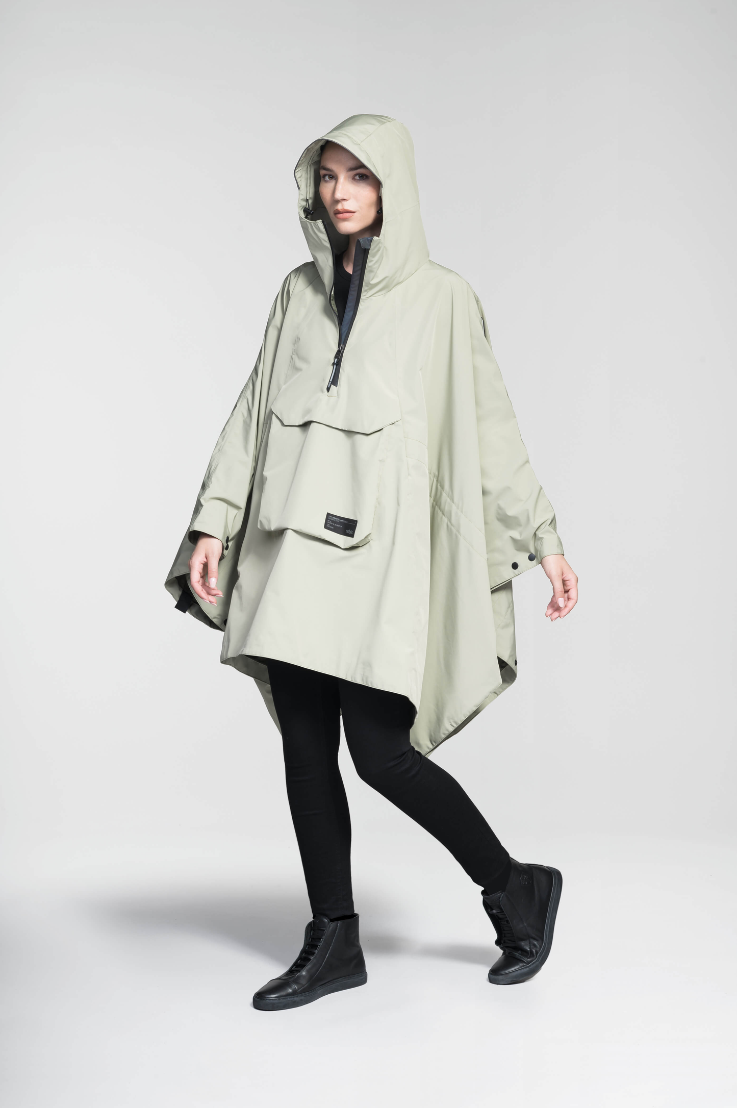 Hydra Unisex Performance Poncho in thigh length, non-removable hood, vertical half-zipper along centre front collar, hidden side-entry waist zipper pockets, adjustable webbing straps and snap closure cuffs, and packable to front kangaroo pocket with flap opening, in Tea
